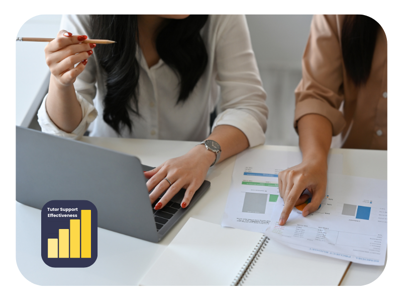 Close-up of two professionals analysing data and reports on a laptop during a marketing apprenticeship in Manchester, focusing on tutor support effectiveness.